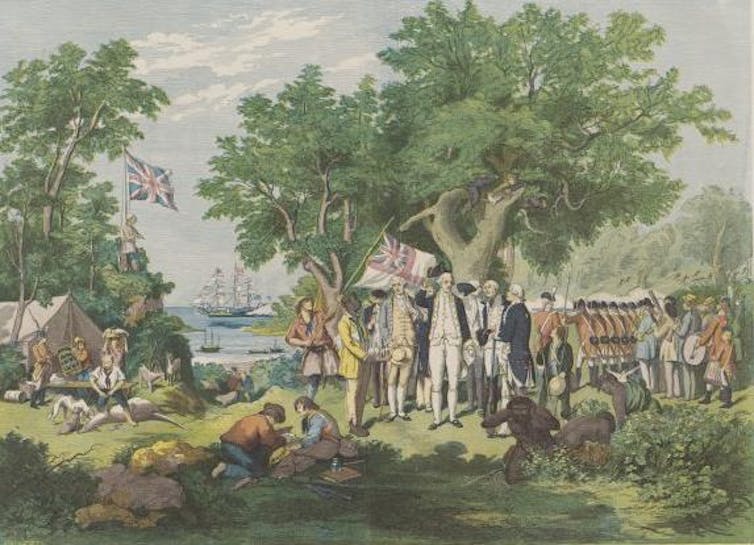 A group of colonial soldiers stand on grass looking at a seated Indigenous people
