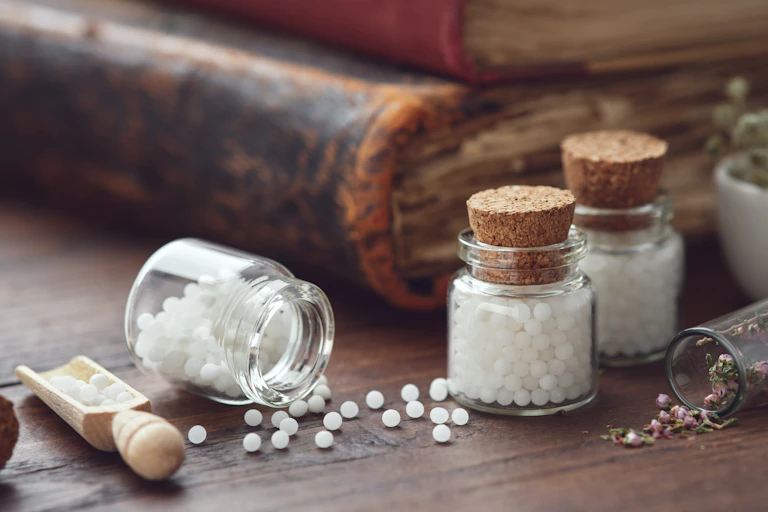 Photo de granules blancs et de fleurs séchées dans des pots en verre.
