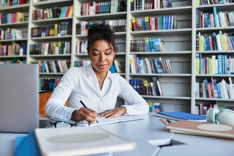 Teacher working on lesson plan in library