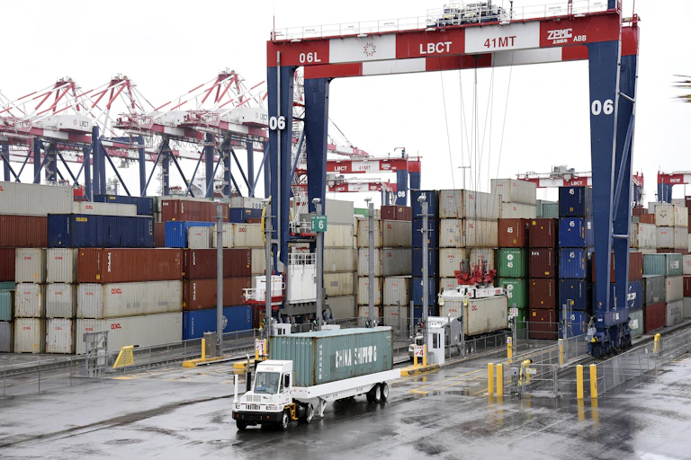 A view of cargo containers and a truck on a cloudy day at the Port of Long Beach.