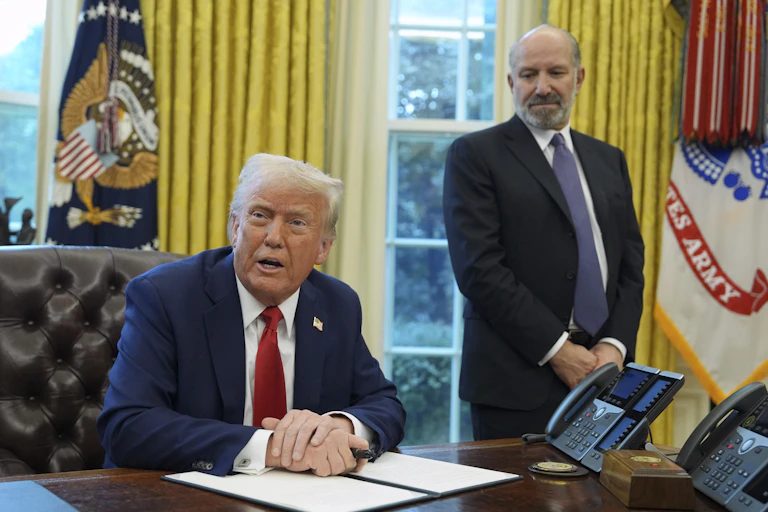 Donald Trump sitting at the desk in the Oval Office