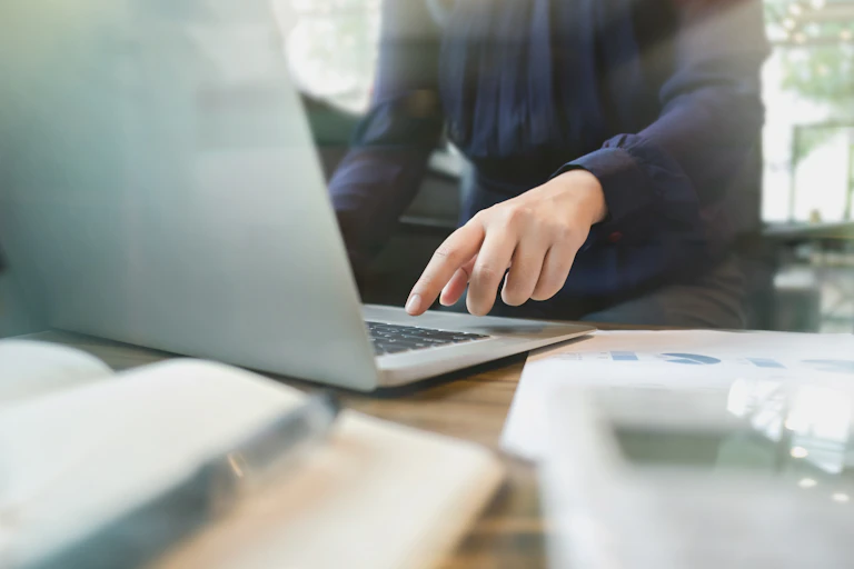 person's hand about to hit button on laptop keyboard