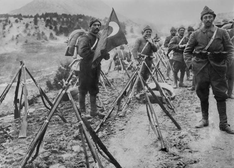 Turkish infantry column at rest with flag and rifles during World War I.