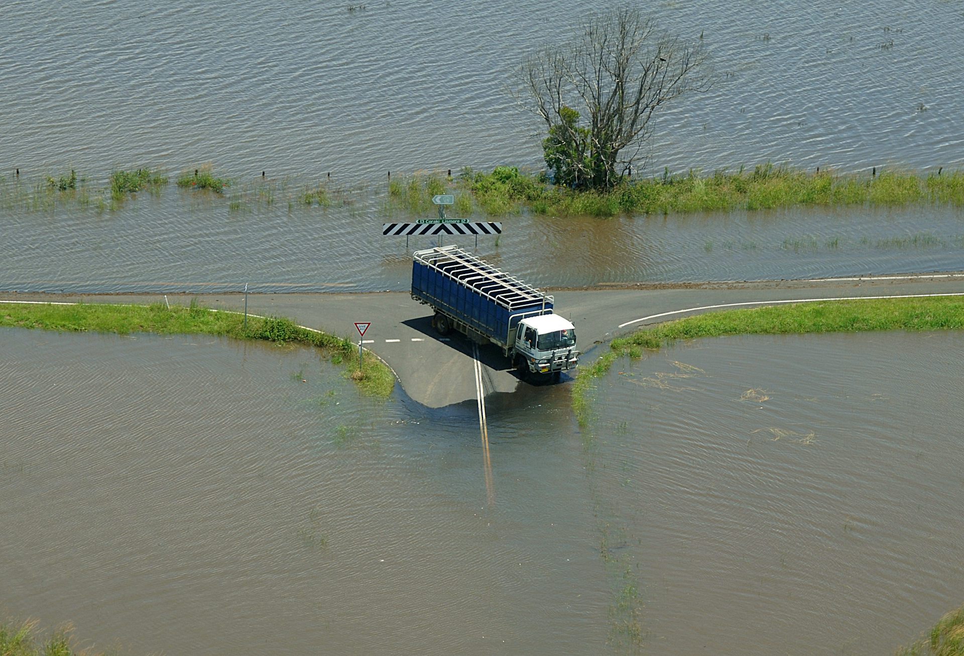 truck stuck on road surrounded by floodwaters