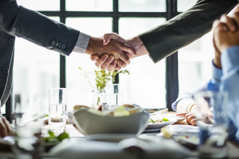 Men shaking hands over a table