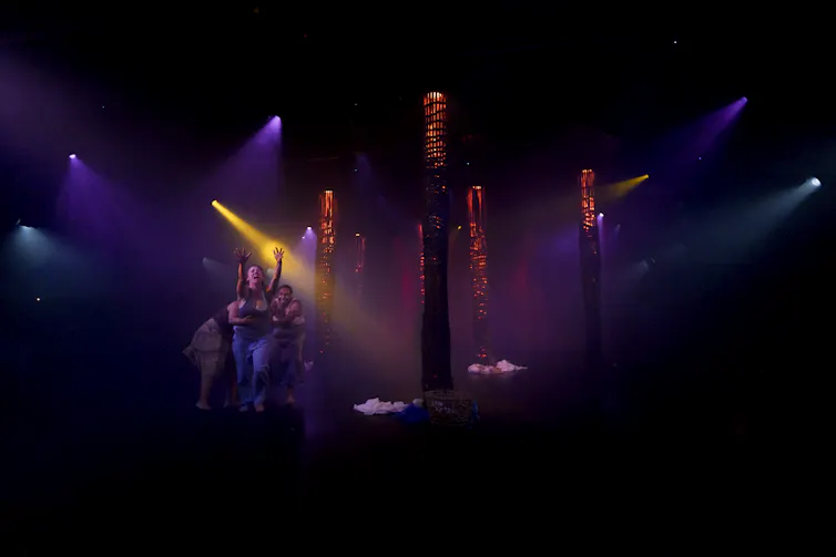 Out of the stage lights, you can just see three women yelling.