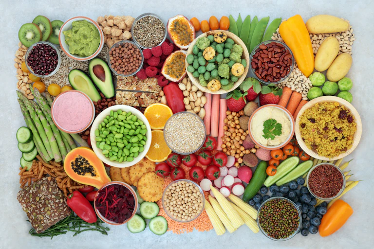 An assortment of plant foods, including cucumbers, chickpeas, edamame, kiwis and cous-cous.