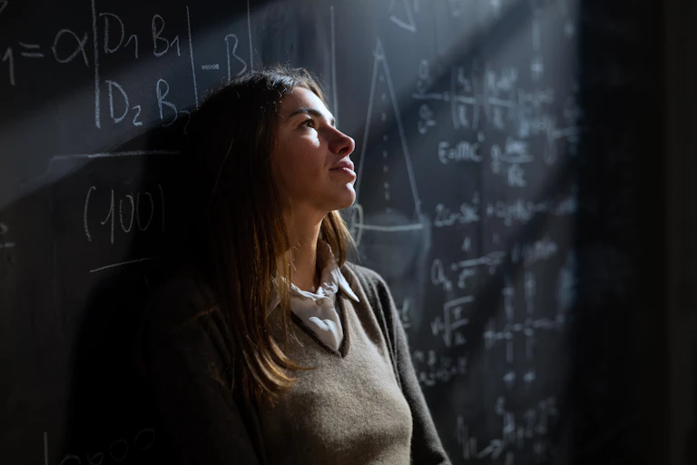 Teacher leaning against blackboard