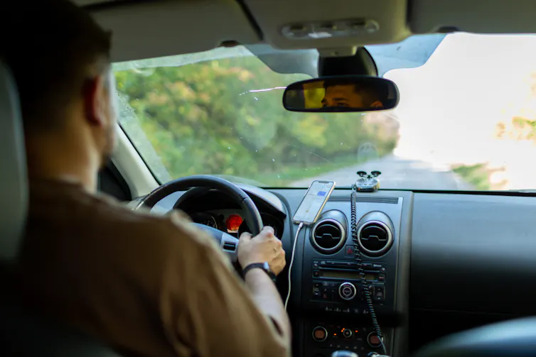 A person behind the wheel of a car.
