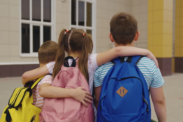Trois élèves avec leurs cartables