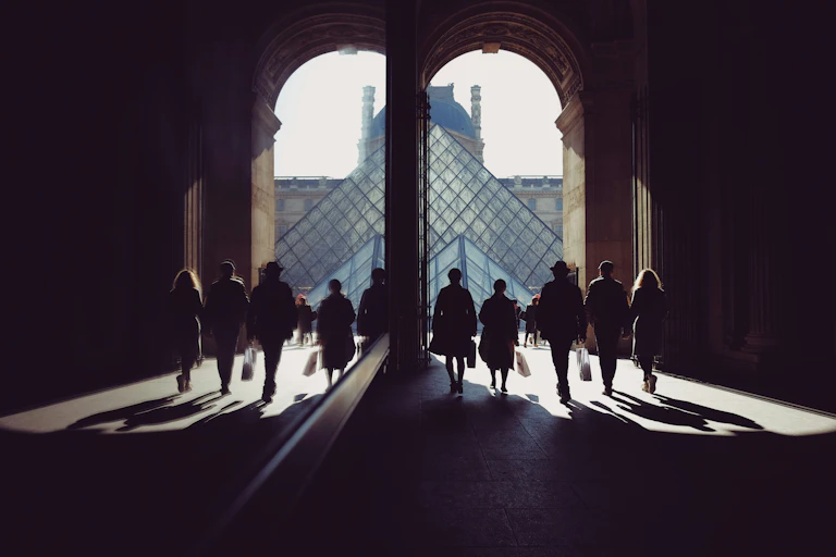 Personnes se dirigeant vers la pyramide du Louvre