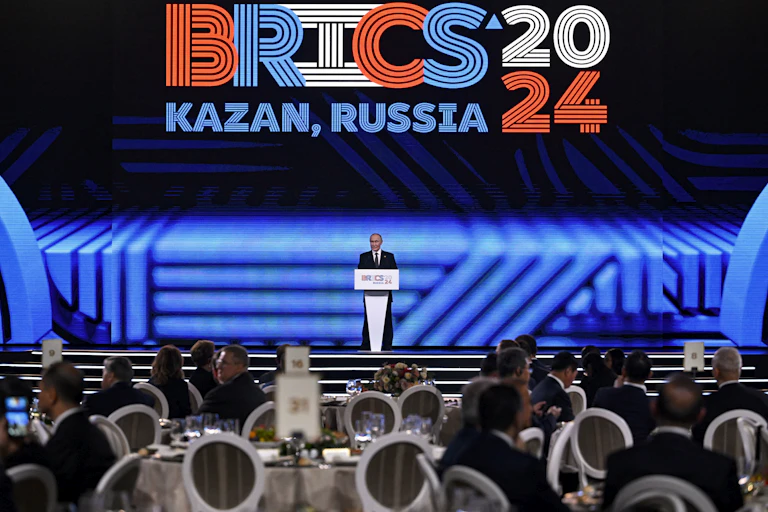 A man in suit addressing a large gathering