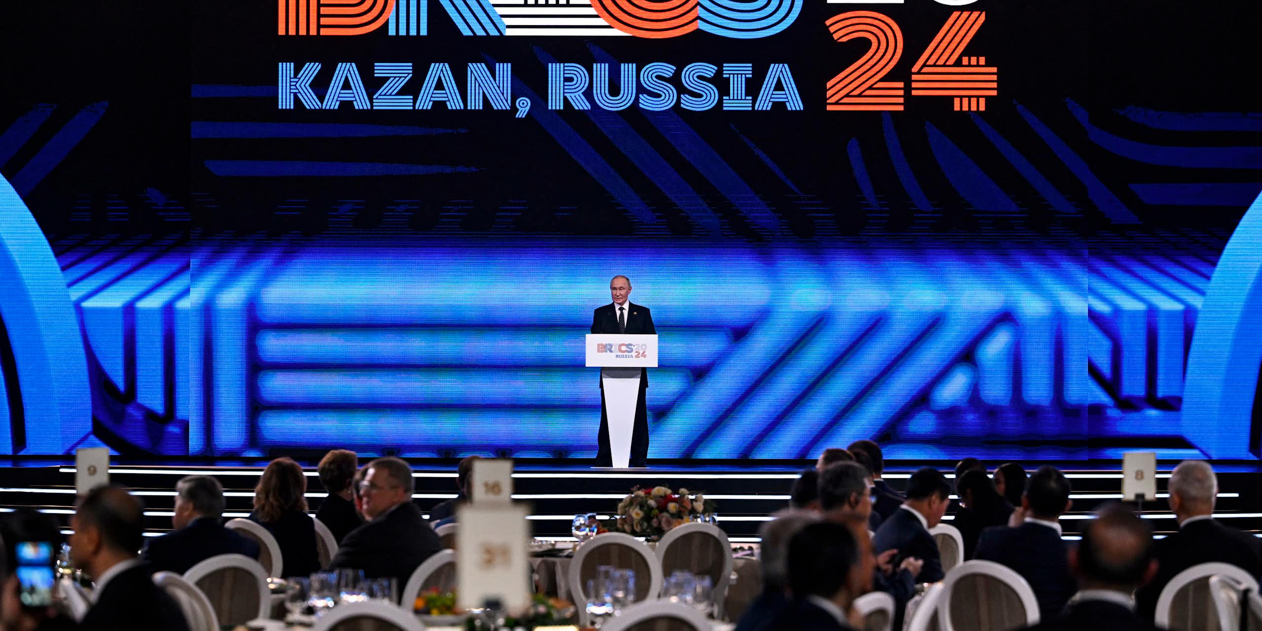 A man in suit addressing a large gathering