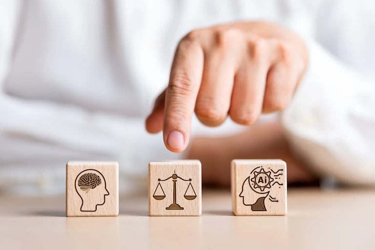 a person's hand points to the middle of three wooden blocks with symbols on them