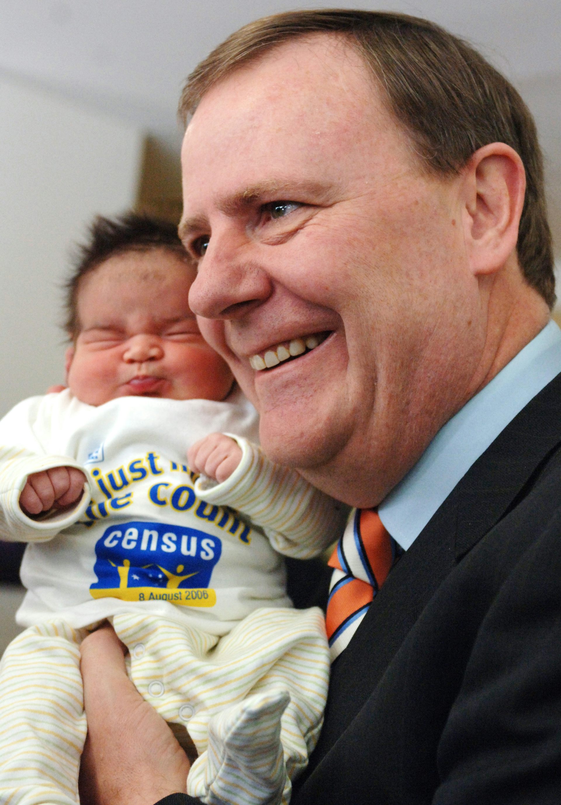 Peter Costello holds a young baby in a hospital