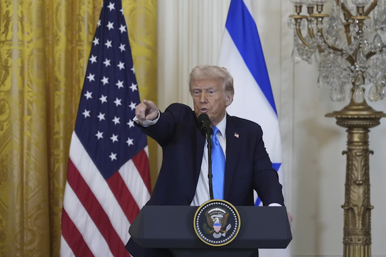 Donald Trump em pé e apontando