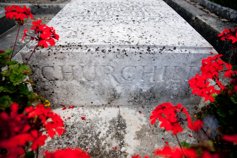 The gravestone of Sir Winston Churchill surrounded by red geraniums.