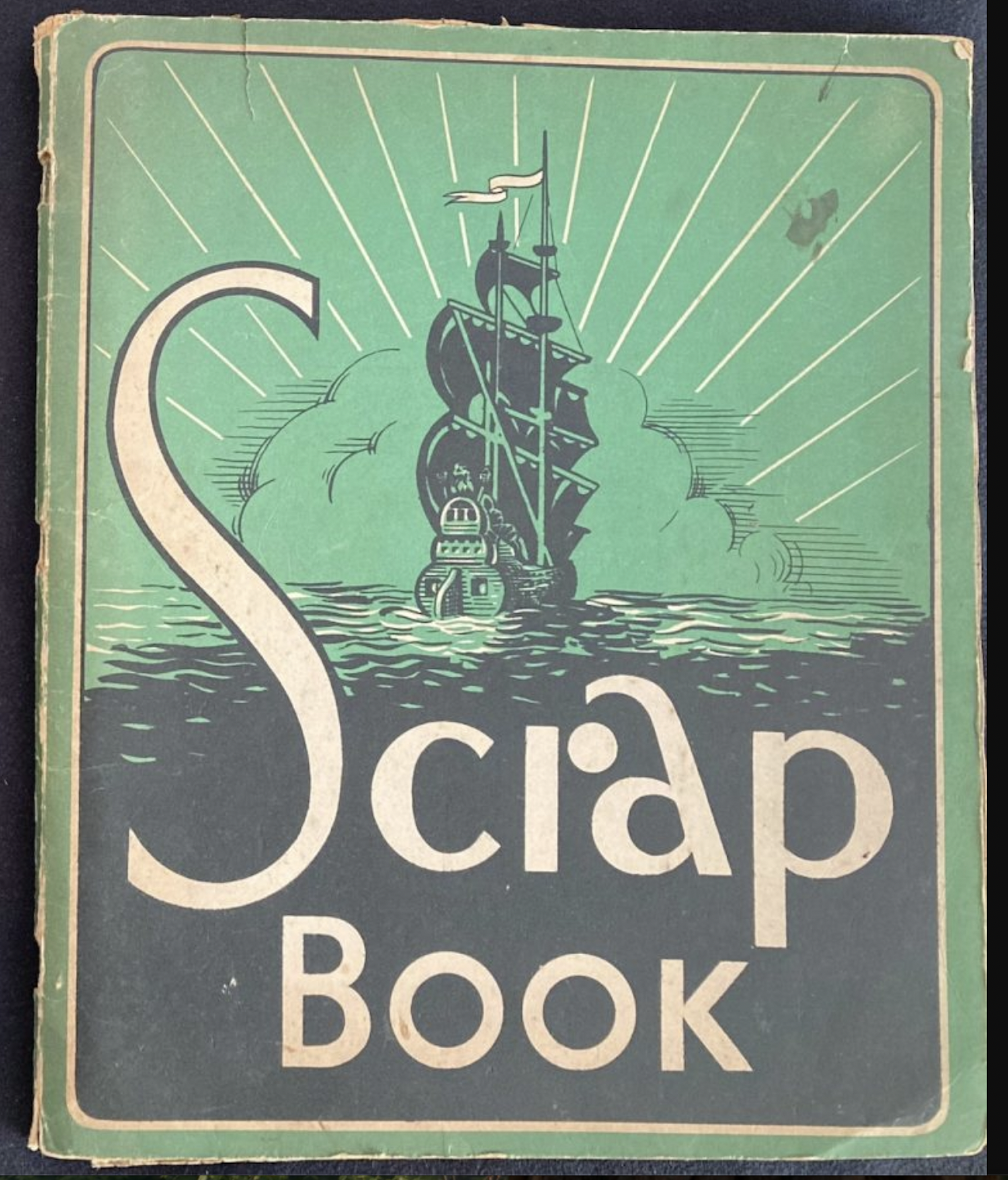 The cover of an old-fashioned scrapbook showing a clipper at sea against a green sky.