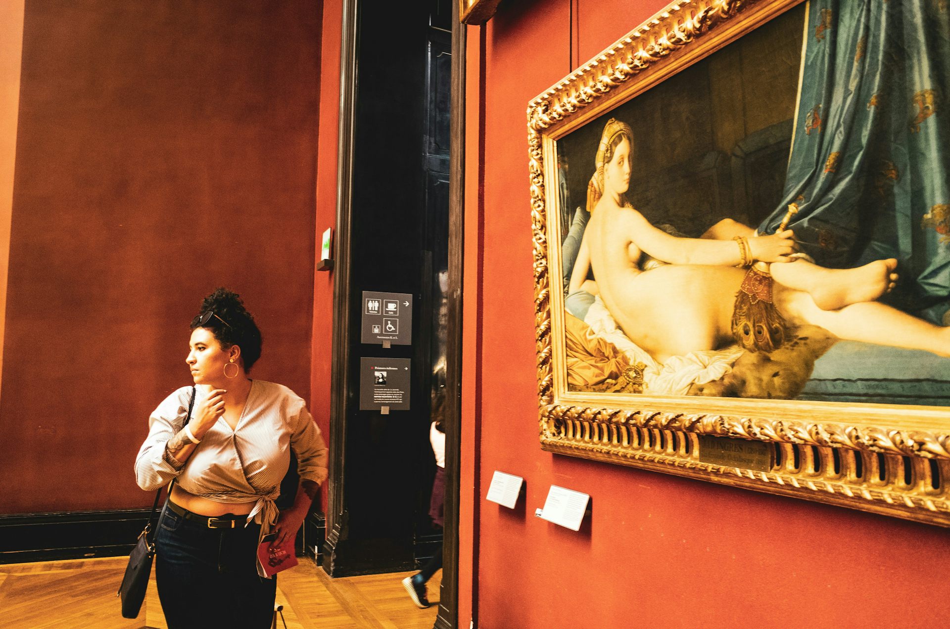 Femme posant devant le tableau « La Grande Odalisque » d'Ingres