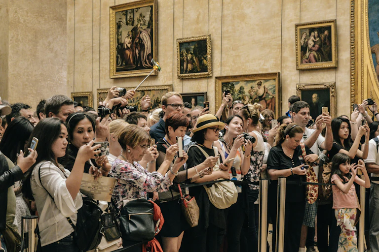 Une foule compacte prend des photos au sein d'une salle du musée du Louvre, à Paris.