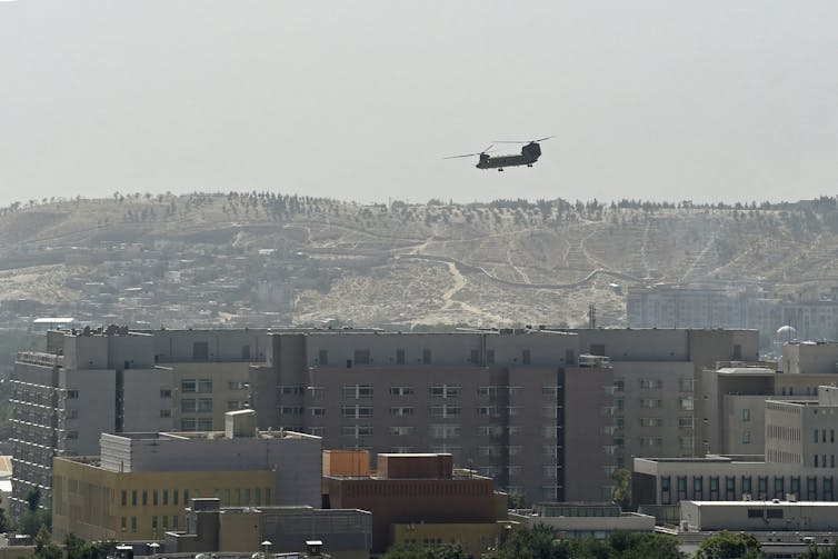 A helicopter flies above a city.