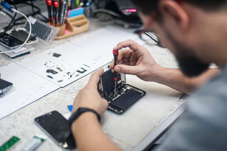 A man unscrews a component in a smartphone