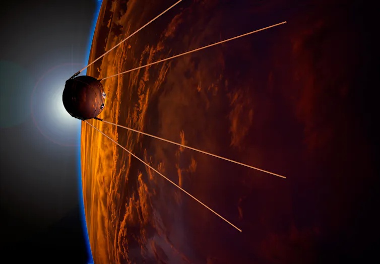 Small circular spacecraft with four antennas flying past an orange planet.