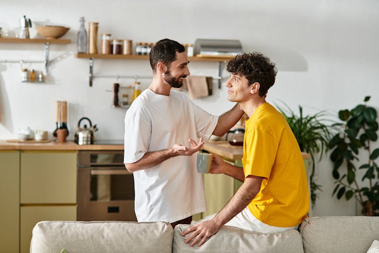 Two men are talking at home.