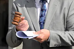 A gavel is held by an auctioneer
