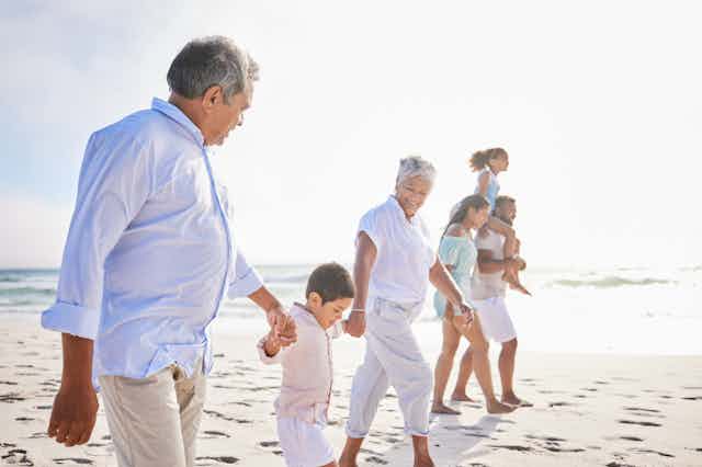 Family of grandparents, parents and children on beach