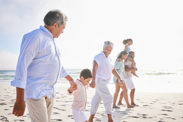 Family of grandparents, parents and children on beach