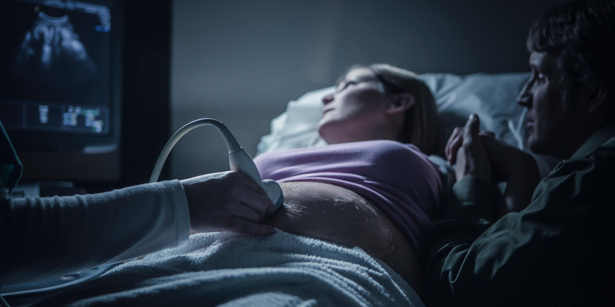A couple looks anxiously at an ultrasound screen.
