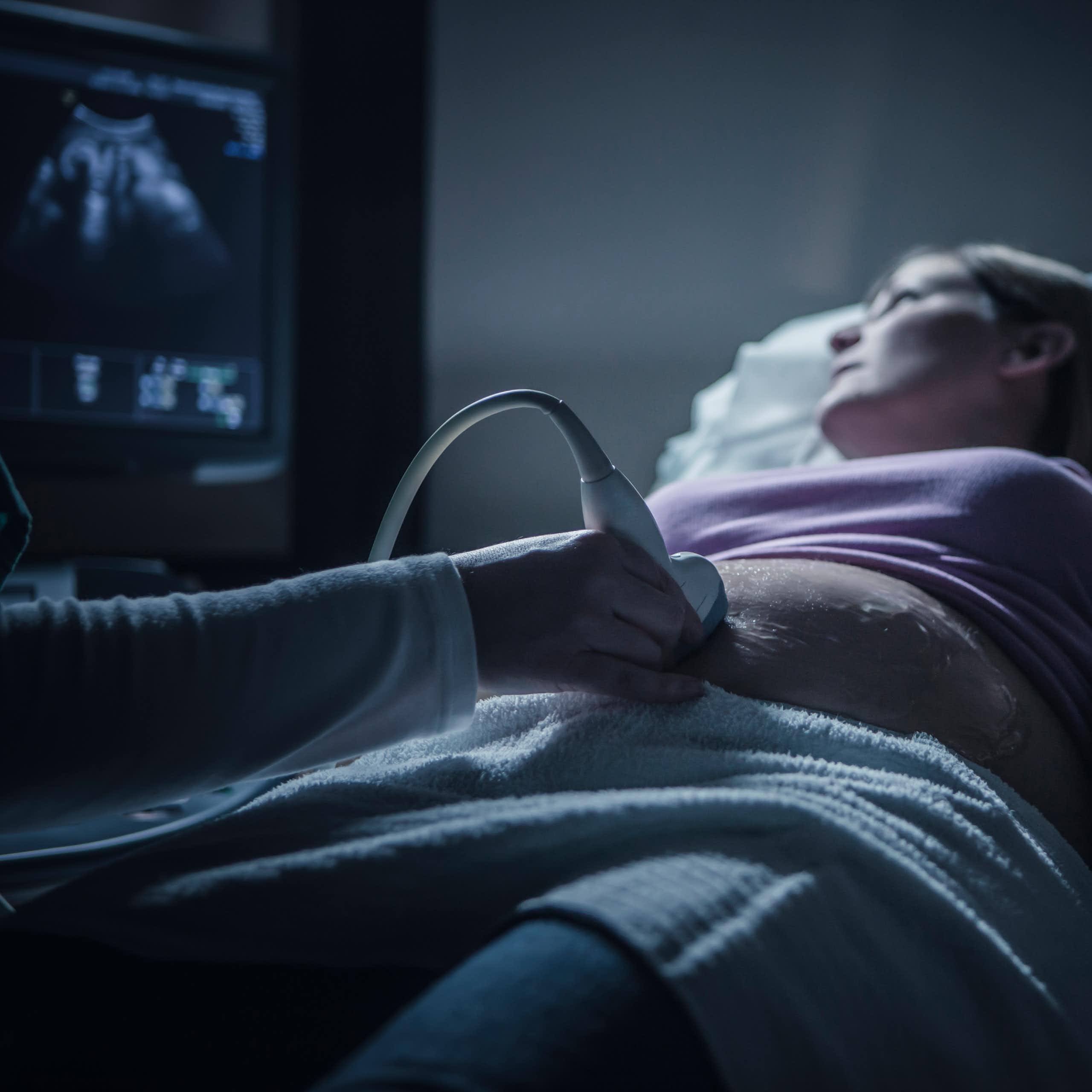 A couple looks anxiously at an ultrasound screen.