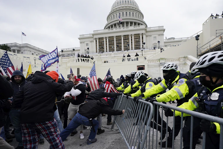 Rioters fight police at metal barricades in front of the U.S. Capitol building.