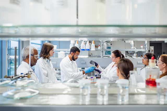 A group of scientists in a lab holding beakers.