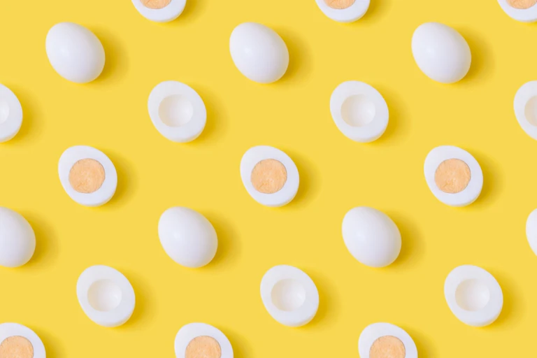Hard boiled eggs cut in half against yellow background