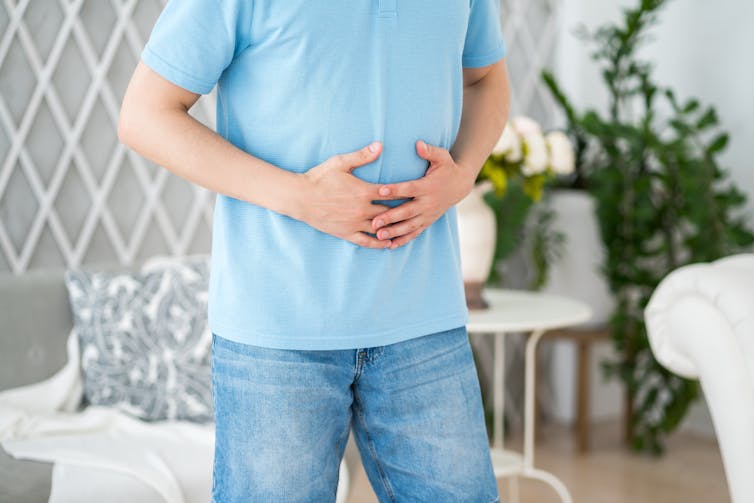 A man holds his stomach.