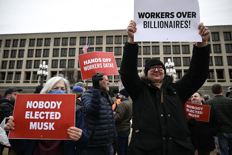Potency − or empire? How Elon Musk’s adverse takeover may finish govt as we comprehend it 2 People hold up signs saying 'Nobody elected Musk,' 'Hands off workers data' and 'Workers over billionaires.'