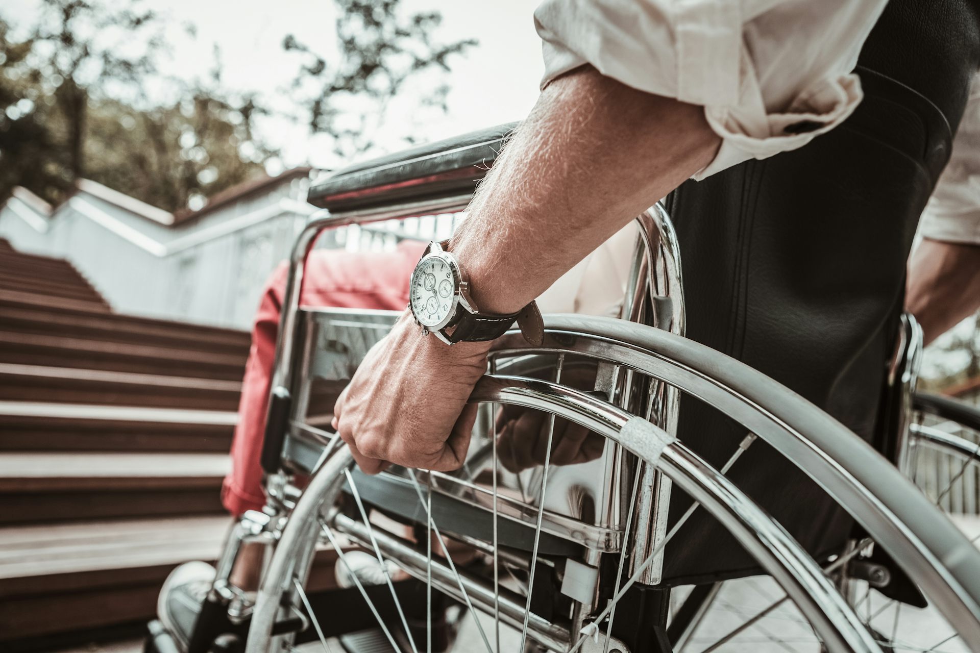 Un homme en fauteuil roulant se trouve devant un escalier