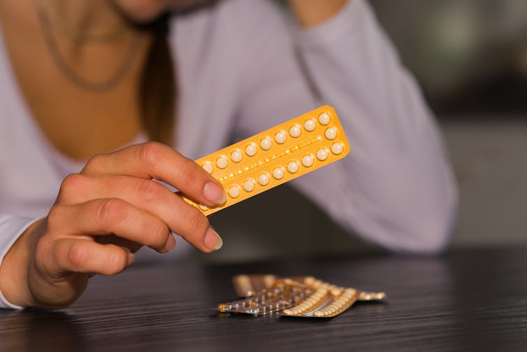 Woman holds pill pack
