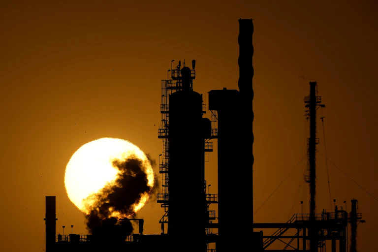 industrial plant in silhouette against the sun