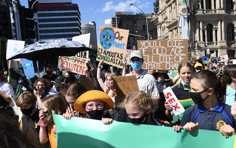 students hold signs at climate rally