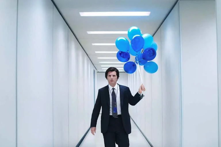 Un homme se promène avec des ballons bleus dans un couloir