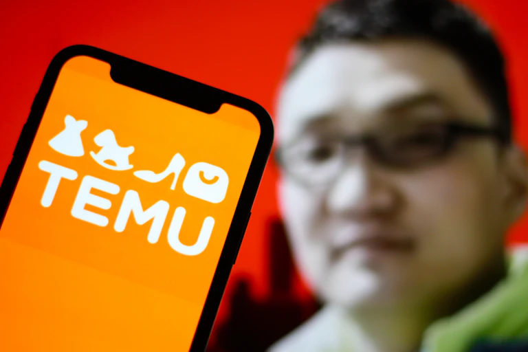 Sur cette photo, le logo de Temu Application est affiché sur un smartphone avec le PDG Colin Huang