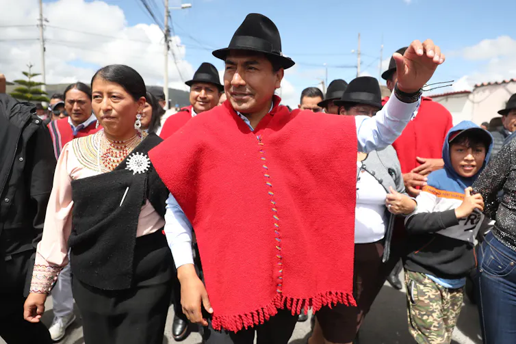 Leonidas Iza dressed in red arriving at a polling station to cast his vote.