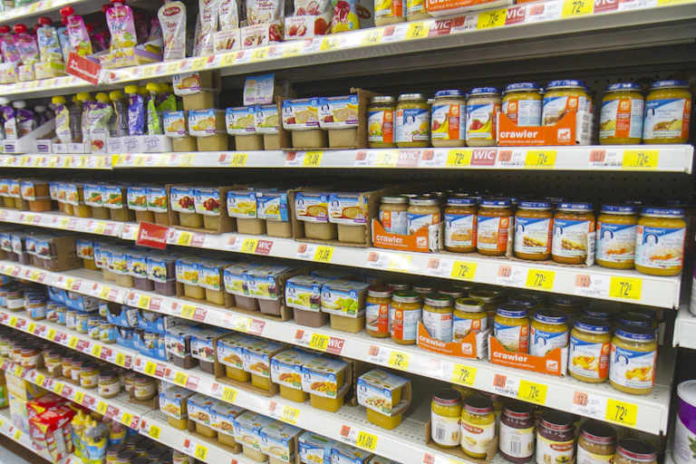 A grocery store shelf filled with baby food jars and pouches