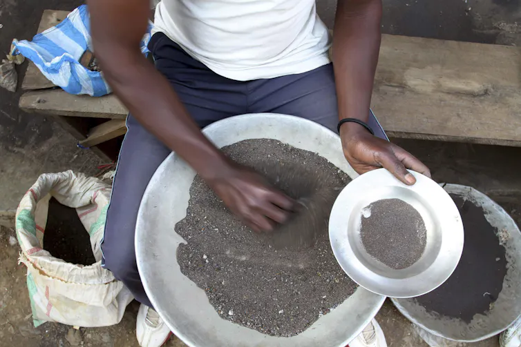 A man sifts through a pile of small rocks and stones