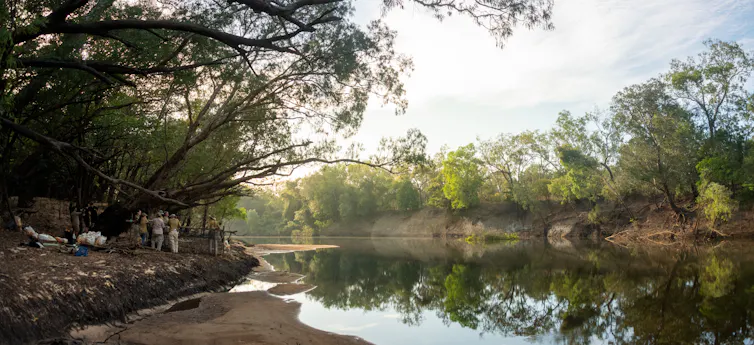 A group of researchers gathered around a crocodile trap site on the banks of the Wenlock River, Queensland.