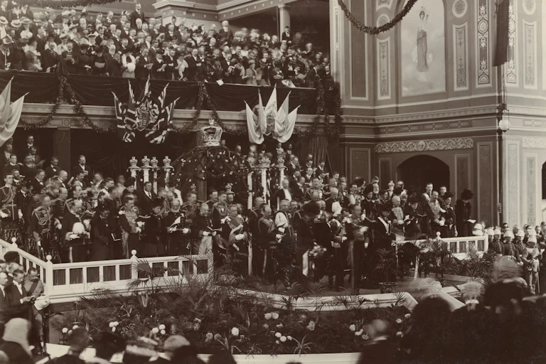 A large crowd of men in suits in an ornate room