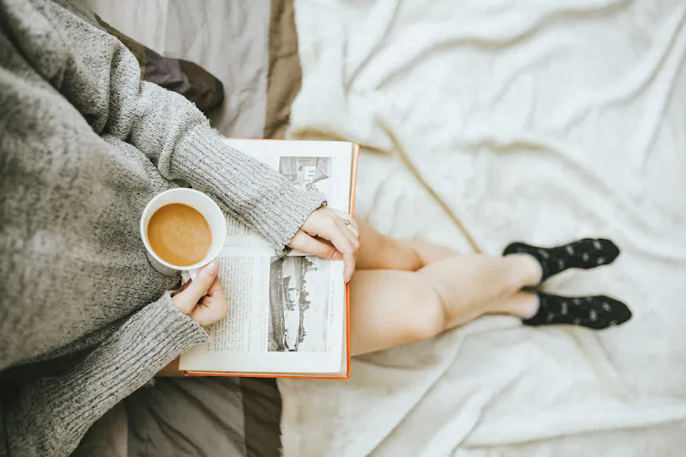 woman reading a book with cup of coffee
